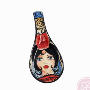 Portacucharas de cerámica flamenca de la artista Catalina Alcaide. Largo: 29 cm y ancho: 10,5 cm. Catalina Alcaide inició su andadura en la decoración de piezas en 1978, trabajando para algunos de los principales talleres de cerámica de La Rambla. Su primera exposición de trabajos tuvo lugar en 1982, en el Palacio de La Merced de Córdoba, con tan solo 18 años. Colaboró en el taller del ilustre escultor, pintor y ceramista Alfonso Ariza, el cual destacó sus méritos otorgándole la medalla de plata en 1982 por su destacada labor como decoradora de cerámica.