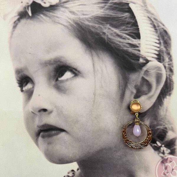 Pendientes para niña compuesto de aro dorado y lágrima de color rosa, de la casa sevillana Carvajal. Complementos únicos realizados artesanalmente, perfectos tanto para eventos especiales como para flamenca.